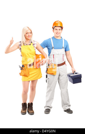 Full length portrait of a male and female construction workers with equipment isolated on white background Stock Photo