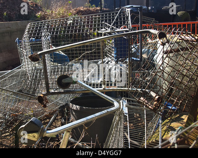 Broken and abandoned shopping trolleys lie piled in a field in Portsmouth England Stock Photo