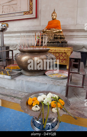 Thailand, Ayutthaya. Phra Mongkonbophit. UNESCO. Buddha temple shrine with offerings of flowers, candles and incense. Stock Photo
