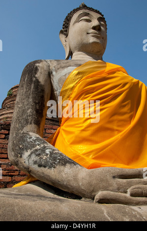 Thailand, Ayutthaya. Wat Phra Chao Phya-thai (aka Wat Yi Chai-mongkol). Seated Buddha statue in yellow robe. UNESCO