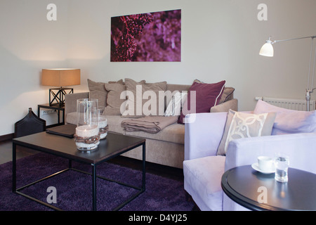 Coffee table on purple area rug in contemporary living room Stock Photo