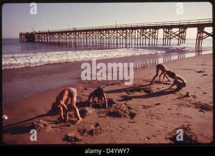 Youngsters play in the sand at the Gaviota State Beach. In the background is the pier, June 1975 Stock Photo