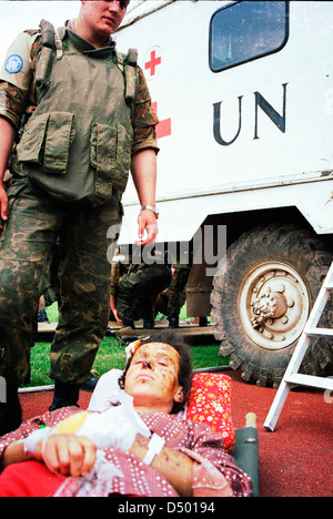 A Ukrainian soldier, in Bosnia with United Nations Protection Force (UNPROFOR), watches over a Bosnian woman wounded during the siege of Gorazde in a temporary medivac facility in the Olympic stadium in Sarajevo, Bosnia, on Monday, April 4, 1994. Stock Photo