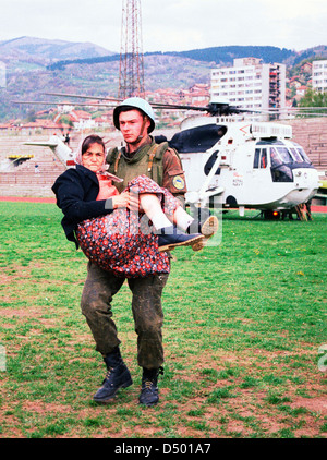 An Ukrainian soldier with the United Nations Protection Force (UNPROFOR) in Bosnia carries a woman wounded during the siege of Gorazde at a medical evacuation center in Sarajevo, Bosnia, on Monday, April 4, 1994. Stock Photo