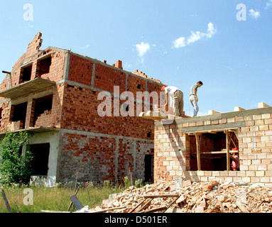 BRCKO, BOSNIA , 08 DECEMBER 1997 ---- Bosnian Moslem men rebuild their home in the contested Bosnian city of Brcko. Thousands of Moslems were ethnically cleansed from Brcko early on in the Bosnian conflict, but with NATO forces guaranteeing their safety many have returned. Stock Photo