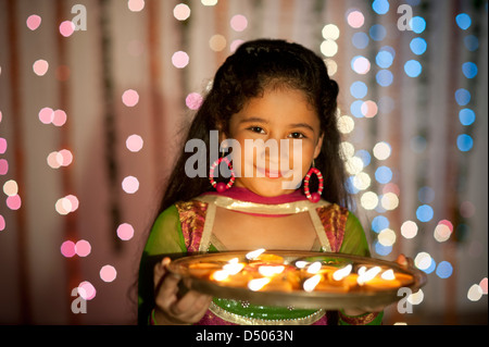 Girl holding a plate of oil lamps on Diwali Stock Photo