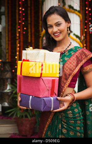 Woman holding a stack of gifts on Diwali Stock Photo