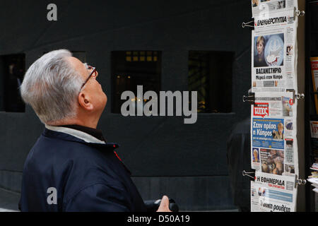 Athens, Greece. 21st March 2013. Man reads Greek newspaper in the center of Athens. Greek press slates Chancellor Angela Merkel for the situation in Cyprus. (Credit Image: Credit:  Aristidis Vafeiadakis/ZUMAPRESS.com/Alamy Live News) Stock Photo