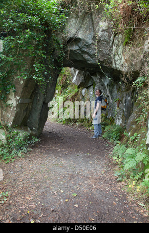 Walker beneath a rock arch in the Devil's Glen, County Wicklow, Ireland. Stock Photo