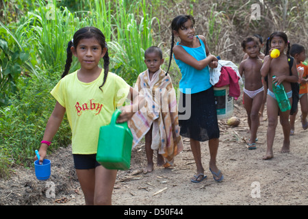 Amerindian girls boys of the Arawak tribe, on their way to the river to wash clothes and themselves. Fair View village. Iwokrama Stock Photo