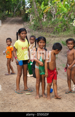 Little girl clothed in re-cycled dress from Western charitable organisation. Guyana. Stock Photo