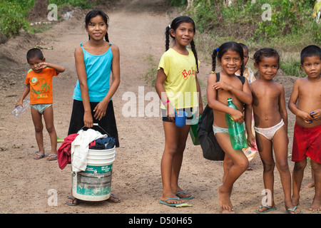 Amerindian girls boys of the Arawak tribe, on their way to the river to wash clothes and themselves. Fair View village. Iwokrama Stock Photo