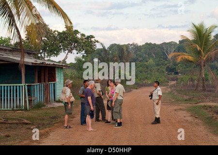 Eco-tourist group visiting an Amerindian community of the Arawak tribe, Fair View village farm plots. Iwokrama Forest, Guyana. Stock Photo