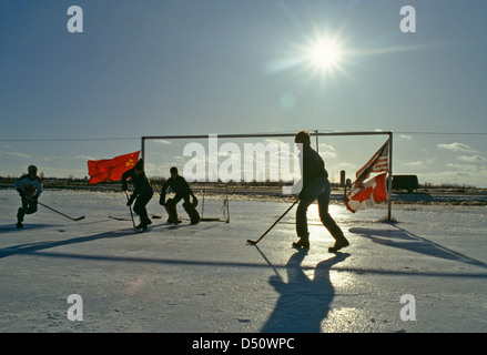 Canada;USA;Russia flags at Canadian Boys are playing Pond Hockey in the winter on a farm outdoors in Ontario;Canada Stock Photo