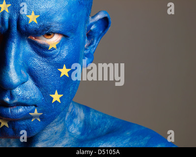 Man with his face painted with the flag of European Union. The man is aggressive and photographic composition leaves only half o Stock Photo