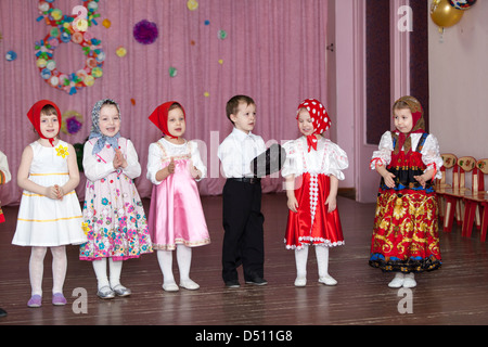 Preschooler girls dancing on the stage in Russian traditional clothes ...