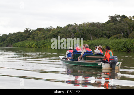 Eco-tourists and local guides travel aboard a motorised boat on River Rewa/Rupununi. North Rupununi. Guyana. Stock Photo