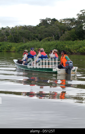 Eco-tourists and local guides travel aboard a motorised boat on River Rewa/Rupununi. North Rupununi. Guyana. Stock Photo