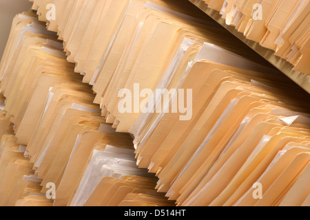 Rows of File Folders Arranged on Shelf with Client Data in Office Setting Stock Photo