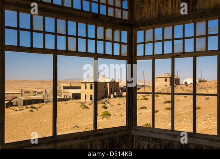 Looking through remains of a window makes for a lonely view over the abandoned houses in the dust blown desert town Kolmanskop