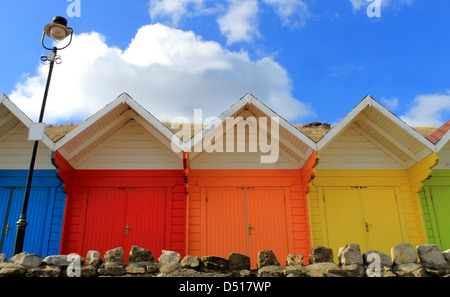 Row of colorful beach chalets with blue sky background. Stock Photo