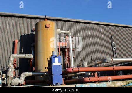 Exterior of modern industrial building with pipes and tank. Stock Photo