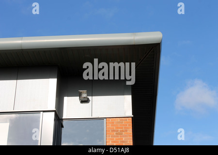 Details of modern office building showing roof and windows, blue sky background. Stock Photo