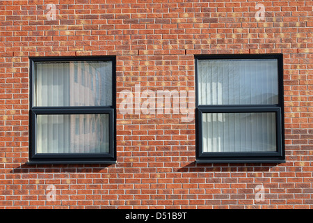 Two office windows in modern red brick office building. Stock Photo