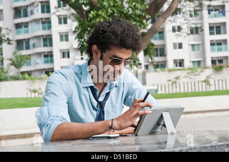 Businessman using a digital tablet in a garden Stock Photo