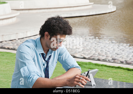 Businessman using a digital tablet in a garden Stock Photo