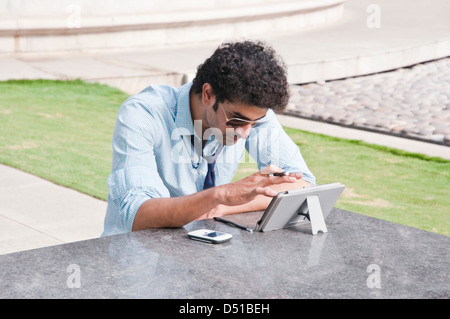 Businessman using a digital tablet in a garden Stock Photo