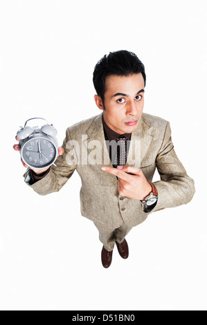 Angry businessman pointing towards an alarm clock Stock Photo