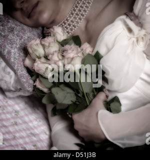 a woman in bed with a bouquet of pink roses Stock Photo