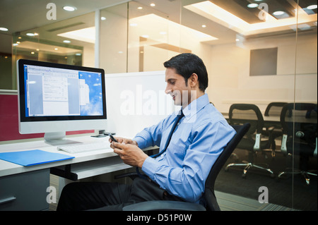 Businessman using a mobile phone and smiling Stock Photo