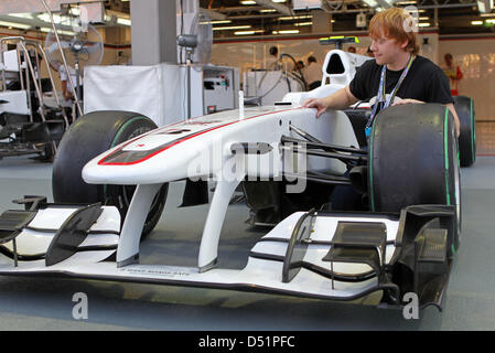 British actor Rupert Grint who plays Ron Weasley in Harry Potter movies poses in front of a Sauber car at the Singapore Grand Prix in Singapore, 26 September 2010. The Singapore Grand Prix Formula One race takes place on 26 September at Marina Bay Street Circuit in Singapore. Photo: Jan Woitas Stock Photo