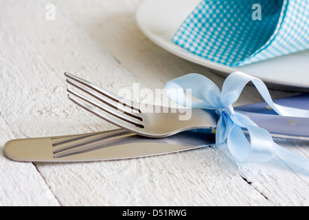 Cutlery and ribbon on old vintage wooden table closeup