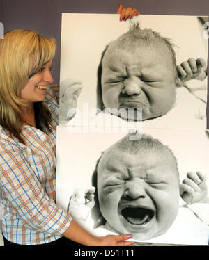 Sarah Klier smiles and hols up two baby photographies of her in her hometown Borsdorf nearby Leipzig, Germany, 26 September 2010. She was the last baby to be born in the GDR on 2 October 2010 and will celebrate her 20th birthday on 2 October 2010. She became famous with the press photograph 'The last cry' (LOWER). The picture was taken shortly after her birth in the Women's Hospita Stock Photo