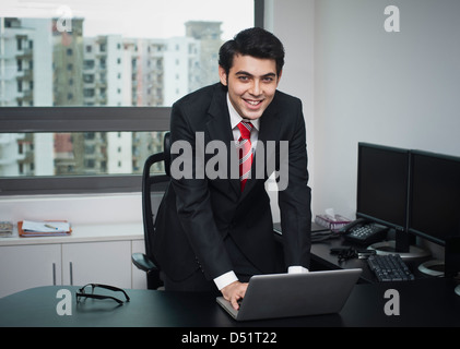 Businessman using a laptop and smiling Stock Photo