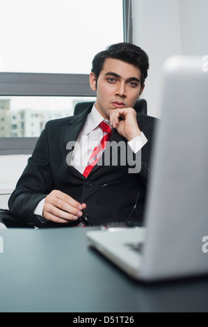 Businessman sitting in his office and thinking Stock Photo
