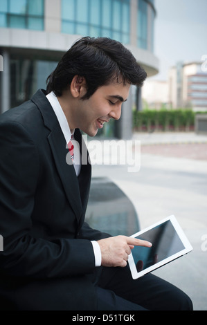 Businessman using a digital tablet and smiling Stock Photo