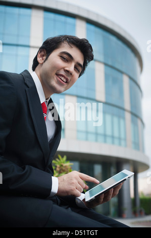 Businessman using a digital tablet and smiling Stock Photo