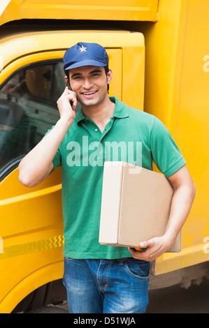 Delivery man talking on a mobile phone Stock Photo