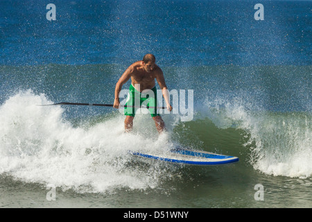 Man surfing inflatable paddle board at Playa Guiones beach, Nosara, Nicoya Peninsula, Guanacaste Province, Costa Rica Stock Photo