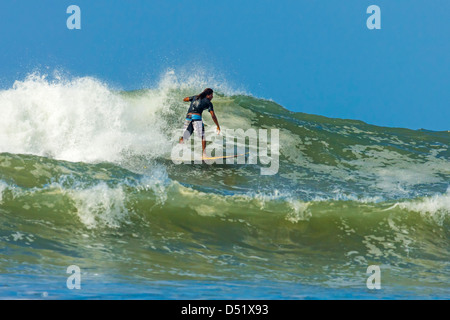 Surfer on shortboard riding wave at popular Playa Guiones beach, Nosara, Nicoya Peninsula, Guanacaste Province, Costa Rica Stock Photo