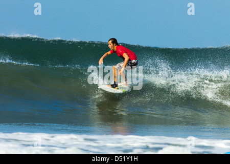 Surfer on shortboard riding wave at popular Playa Guiones surf beach, Nosara, Guanacaste Province, Nicoya Penninsula, Costa Rica Stock Photo