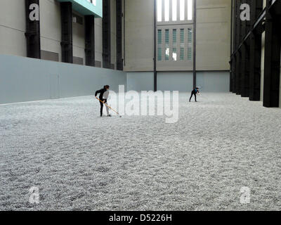 An installation made out of 100 million handmade porcelain sunflower seeds by Chinese artist Ai Weiwei is being tended to by employees at the Tate Modern in London, Great Britain, 11 October 2010. The installation was a commissioned work for Tate Modern's Unilever Series. Photo: Barbara Bentele Stock Photo