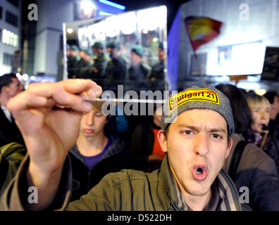 An opponent of the controversial railway construction project Stuttgart 21 faces police officers with a mirror in front of a hall that hosts a discussion of the project's proponents in Stuttgart, Germany, 11 October 2010. During last week, violent riots between protesters and police forces occured. Photo: Bernd Weissbrod Stock Photo