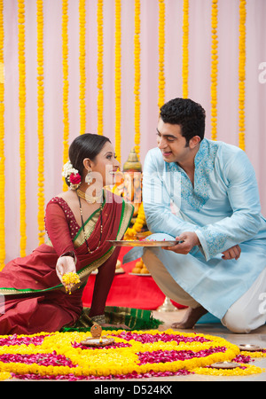 Maharashtrian couple making flower rangoli during ganesh chaturthi festival Stock Photo