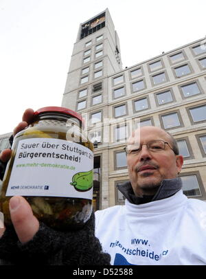 An opponent of the controversial railway project Stuttgart 21 protests with a jar of pickled cucumbers in front of city hall in Stuttgart, Germany, 18 October 2010. In reference to a German idiom that equates the dish with discontent and foul play, protesters have set up more than 7,000 pickled cucumbers in front of city hall. More than 7,000 people participated in today's protests Stock Photo