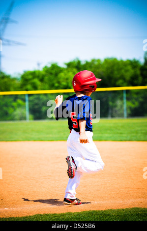 Youth little league player running bases. Stock Photo